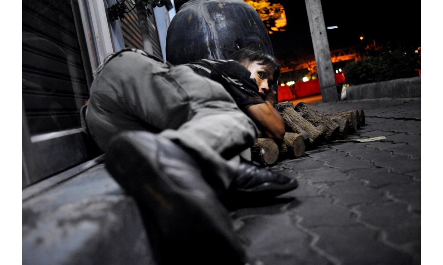 © Agnès Dherbeys / MYOP Beginning of the Battle of bangkok after the killing of Gen. Seh Deang in the red zone: Rama IV road, a red shirt supporter tries to take cover while we are targetted by unknown shooters from the Lumpini park direction, Bangkok Thailand, 13/05/10