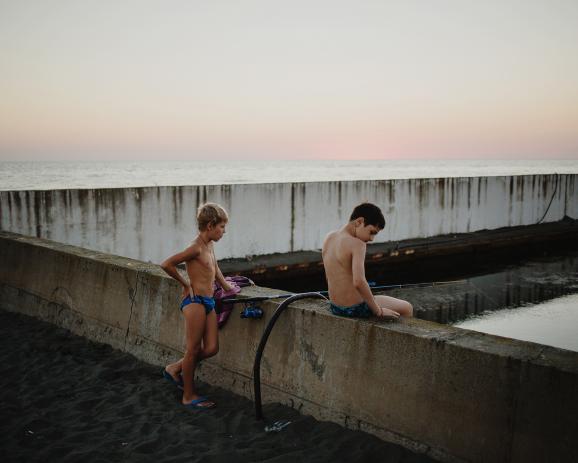 Anaklia, Samegrelo, Georgia - two young boys are fishing in the small and empty yacht port.